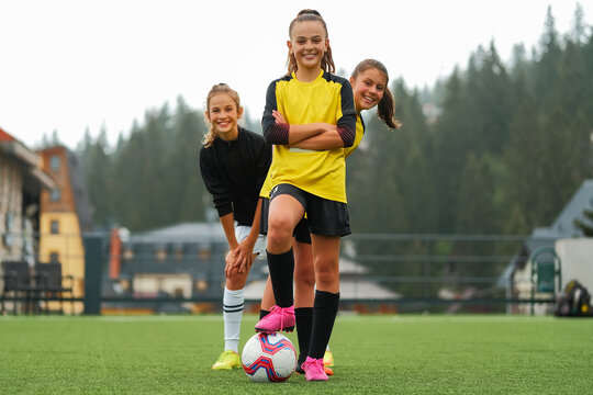 A happy female soccer team together on the stadium field.