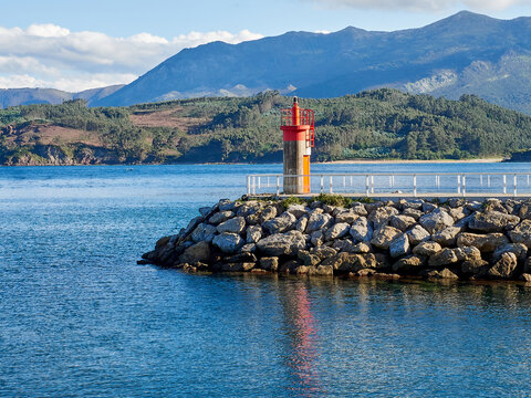 Lighthouse reflected in the sea in the harbor of Lastres. Llastres, Colunga, Asturias, Spain, Europe