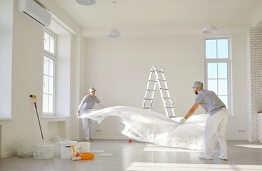 Painters team or construction workers planning repair, floor covering to protect during color...