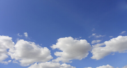 Clear blue sky, sunny day, soft white clouds, ideal peaceful background, weather-related concepts, sunlight shining brightly, calm soothing environment, expansive overhead view in thailand