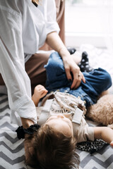 Mother and child on patterned floor, gentle interaction. Parenting moments, child care, cozy indoor setting, maternal bond, early childhood development.