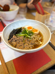 Ramen soup with meat, noodles, egg and pak choi in restaurant. Japanese cuisine