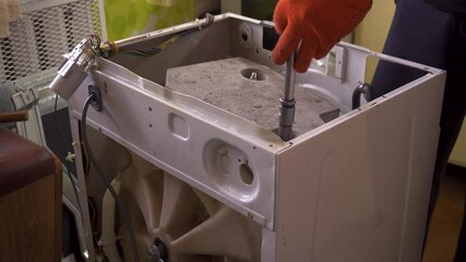 Plumber repairs the washing machine. Man fixes washing machine