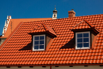 2023-05-09; Red roof with windows against the backdrop of a cathedral