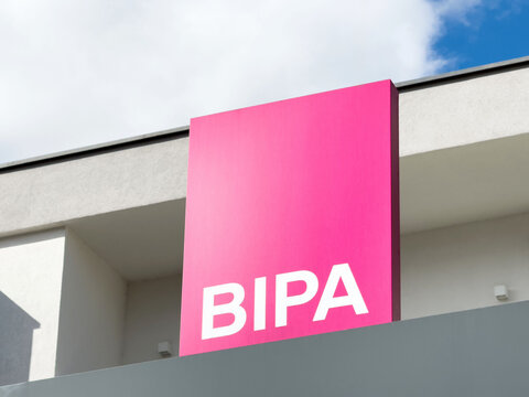 Bright pink bipa sign against modern building and sky background