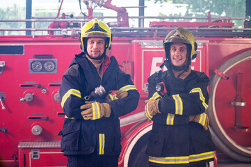 Firefighters in fire fighter safety suit stand in front of Fire truck in emergency situation.. -...