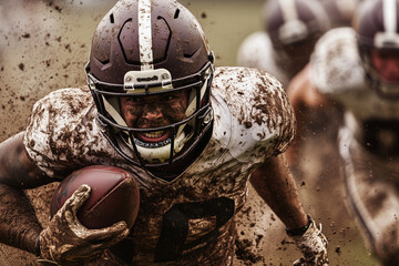 football player is running with a muddy football in his hands. The player is wearing a helmet and a jersey with the number 10 on it