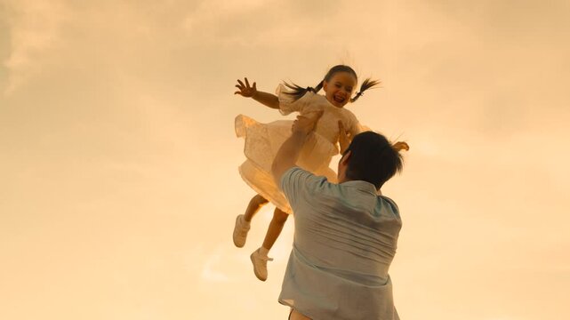 father throws child kid daughter into sky, silhouette happy family, children dream flying airplane pilot, family silhouette against sunset, daughter flying high, family twilight play, child in sky