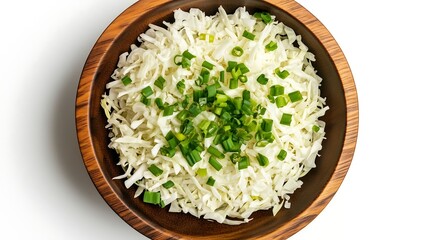 Shredded cabbage with chopped spring onions in round wooden bowl, top down view, white background, food vegetables ingredients
