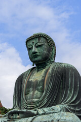 Obraz premium Historic Great Buddha of Kamakura seated in deep meditation with closed eyes and hands resting in a symbolic gesture with weathered bronze textures