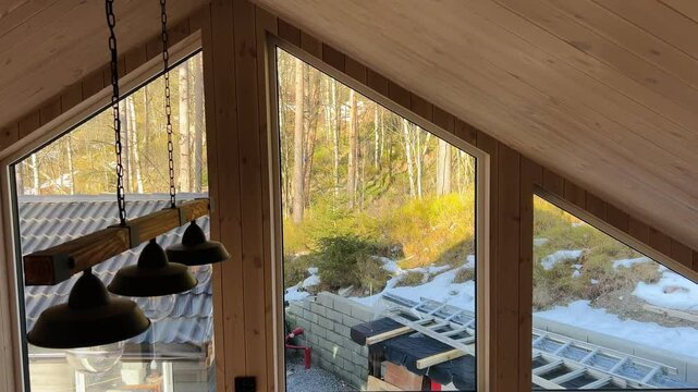 Modern house under construction with large windows. Summer house. Modern Forest House. Wooden Tiny House Interior And Triangular Window. Luxury log cabin. Stylish home with efficient design.