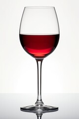 Elegant red wine glass filled with deep crimson liquid against a soft light background.