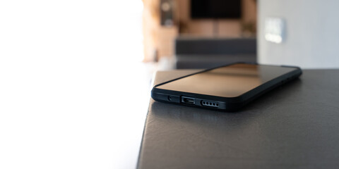 Smartphone lying on table in bright modern home interior