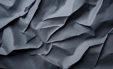 Obraz premium Close-up of crumpled gray paper creating a textured, abstract pattern. 