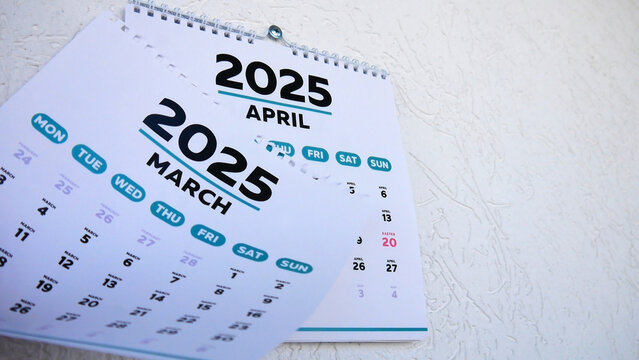 Close-up of a tear off March 2025 page of a wall calendar followed by the next one with the marked date of Easter