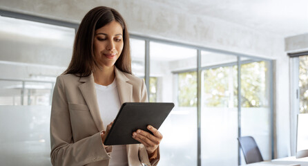 Financial specialist businesswoman manager using pc tablet for sales management, online banking operations. Latin or middle eastern business woman working on computer at office. Banner, copy space