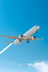 Fototapeta premium airplane at cruising altitude leaving sharp contrail across rich blue sky