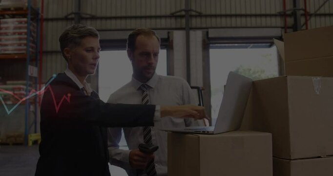 Analyzing data on laptop, business professionals in warehouse working together