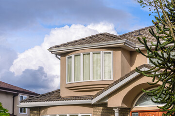 Top of luxury house with shingle roof, red and yellow trees and nice windows in Summer in Vancouver, Canada, North America. Day time on June 2024.
