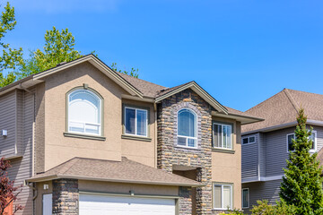Top of luxury house with shingle roof, red and yellow trees and nice windows in Summer in Vancouver, Canada, North America. Day time on June 2024.