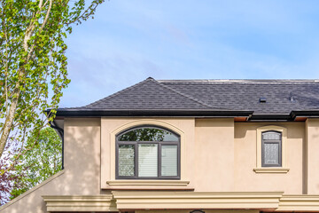 Top of luxury house with shingle roof, red and yellow trees and nice windows in Summer in Vancouver, Canada, North America. Day time on June 2024.