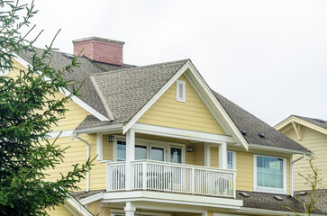Top of luxury house with shingle roof, red and yellow trees and nice windows in Summer in Vancouver, Canada, North America. Day time on June 2024.