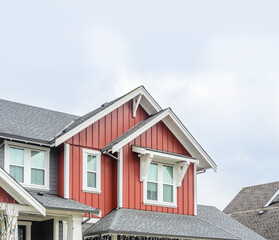 Top of luxury house with shingle roof, red and yellow trees and nice windows in Summer in...
