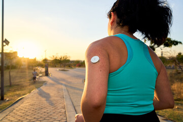 Diabetic patient woman doing exercises. Continuous Glucose Monitor and active sugar diabetes lifestyle