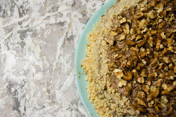 Delicious homemade cake with meringue, peanuts and walnuts on a light background. Concept of natural homemade baking