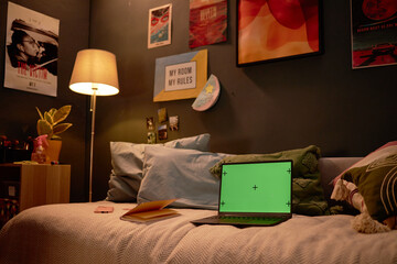 Room with dim lighting, featuring a sofa with pillows, an open laptop on a desk, and various...