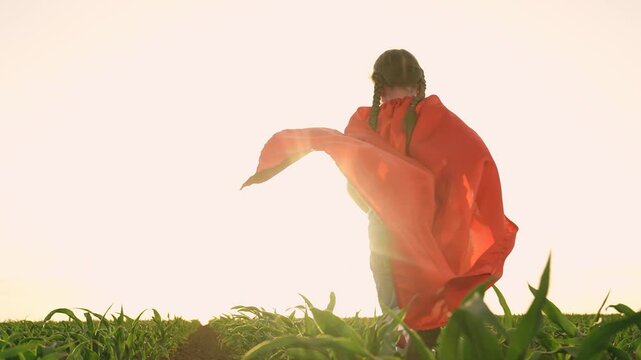 little child kid superhero costume runs through corn field, agriculture, happy family, childhood dream flying, child kid girl running sunset rubber boots, child kid running red cape, airplane pilot