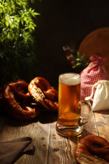 A mug with beer and traditional German bretzels in Bavarian rustic style