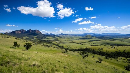Obraz premium Breathtaking Wide Open Green Valley Surrounded by Mountains Under a Clear Blue Sky : Generative AI