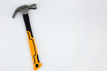 A hammer with an iron base and a yellow and black handle lies on a white background on the left with space for text. The concept of repair, hammering. High quality photo