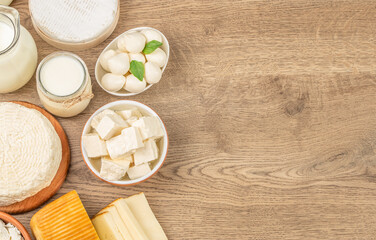 dairy and dairy products on wooden background. Milk, sour cream, mozzarella, kefir, yogurt, cheese assortment. top view. copy space