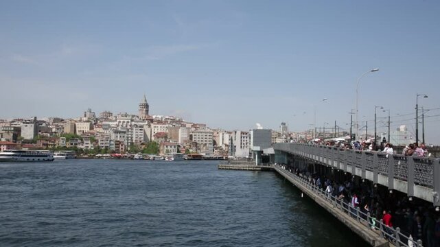 TURKEY, ISTANBUL - MAY 15, 2015: Galata Bridge and mosque Eminonu ( New Mosque) in the evening. Galata Bridge (Galata Koprusu) - the bridge through a bay the Gold Horn.