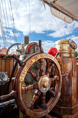 A large wooden steering wheel with the word Escuela de Guardias on it. The wheel is surrounded by a wooden structure