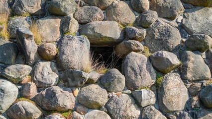A stone wall with a glass window, harmoniously combining natural materials with modern design.