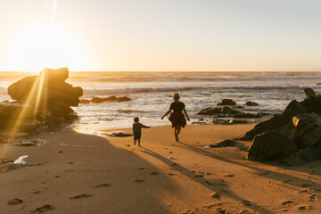 Mother and son on the ocean shore at sunset. Mother's love for her child