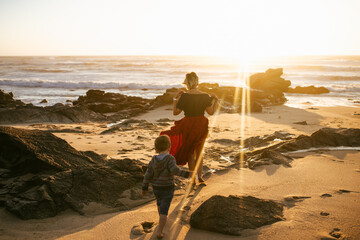 Mother and son on the ocean shore at sunset. Mother's love for her child