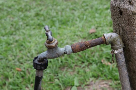 Una toma de cerca de  una tuber&iacute;a vieja con una llave de agua para regar el jard&iacute;n