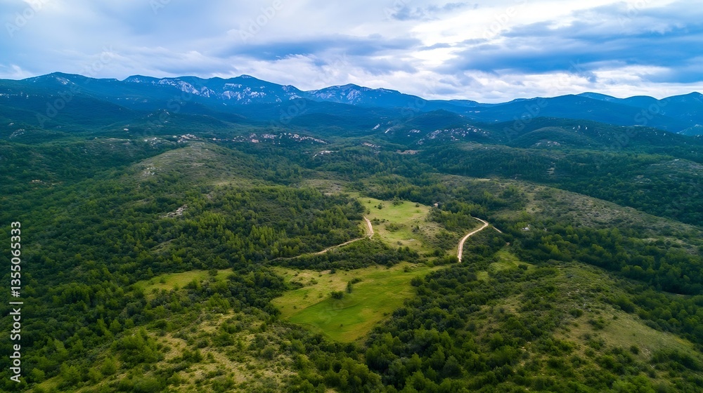 Aufkleber Aerial view of rolling hills and lush greenery leading to distant mountain range under cloudy sky : Generative AI