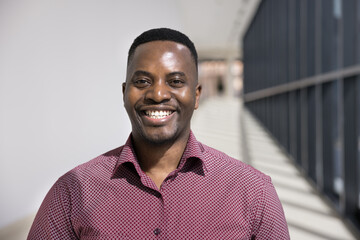 Head shot portrait of satisfied African businessman, corporate staff member looking at camera,...