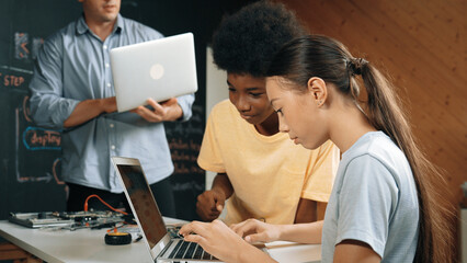 Group of diverse student working together to write program. Multicultural children coding or...