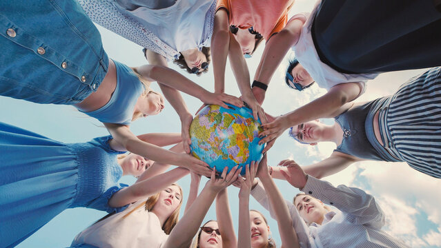 School friends demonstrate their commitment to environmental protection and global citizenship by holding a globe