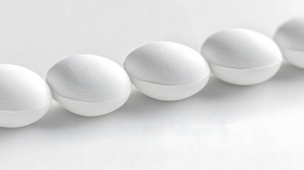 Line of Smooth White Pills on a Clean Surface against a Minimalistic Background
