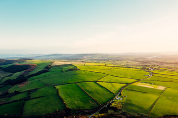 Aerial View of Scenic Green Fields and Countryside Road in Wicklow, Ireland at Sunset