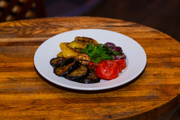 Grilled baked vegetables in a white plate on a wooden table. tasty healthy food. healthy eating.general meal plan