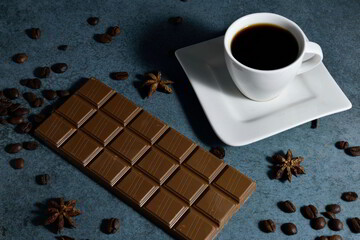 Cup of espresso and chocolate with coffee beans on the side .