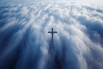A large cross rises dramatically through a dense blanket of clouds during sunrise, creating a serene atmosphere filled with light and optimism. The clouds create a beautiful, soft backdrop